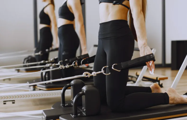 小諸市で姿勢改善を目的にピラティスリフォーマーを使用してトレーニングする複数の女性の様子